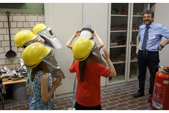 Kinder probieren Schutzkleidung in der Gießerei an