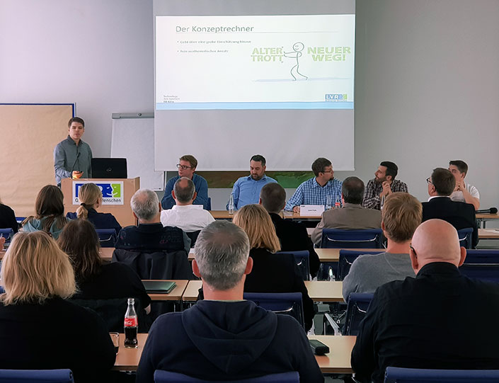 Eine Gruppe von Studenten präsentiert Ergebnisse vor einer größeren Gruppe von Zuhörerinnen und Zuhörern Eine Gruppe von Studenten präsentiert Ergebnisse vor einer größeren Gruppe von Zuhörerinnen und Zuhörern