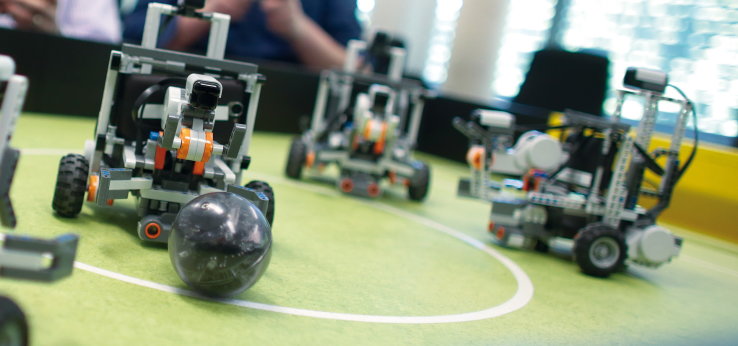 3 Legoroboter spielen auf einem Fussballtisch Fussball (Bild: Manfred Stern / TH Köln)