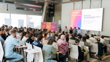 Die fünfköpfige Paneldrunde sitzt vor den gefüllten Reihen des Hörsaals 2. (Bild: ChemCologne)