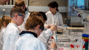 Die jungen Forscher*innen geben Natriumalginat-Lösung tropfenweise mit einer Pipette in flüssiges Calciumchlorid. (Bild: TH Köln - Media Lab)
