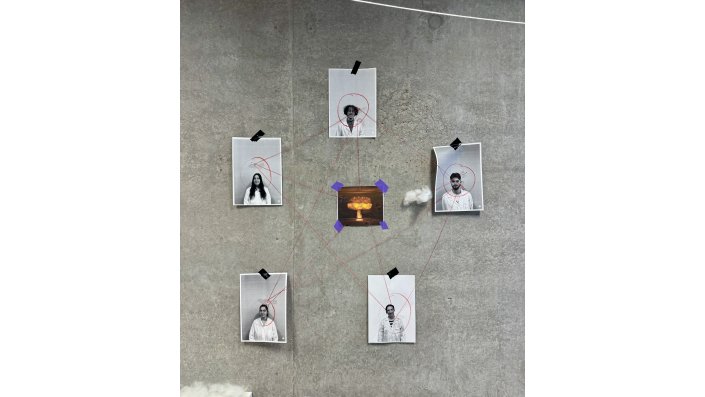 An einer Wand hängen vier Proträtbilder und eine Zeichnung