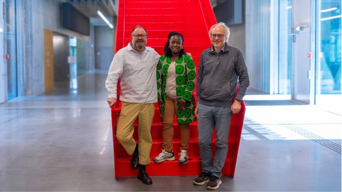 Prof. Dr. Séphan Barbe, Dr. Ossénatou Mamadou und Dr. Philipp Davis stehen vor der roten Treppe