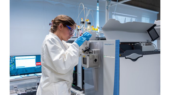 Ida Schirrmeister steht am Massenspektrometer und kalibriert das Gerät.