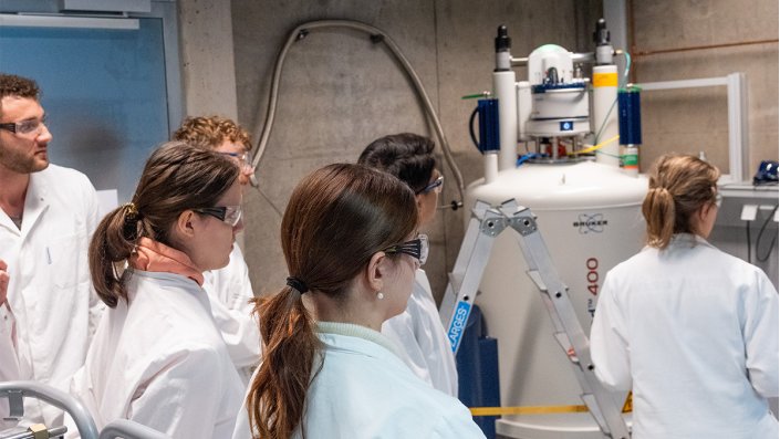 Sechs Personen stehen vor einem NMR.