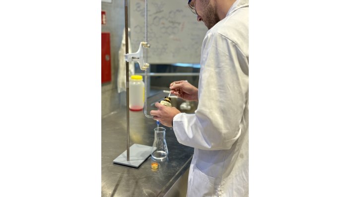 Ein Escape Building-Teilnehmer löst eine chemische Substanz in einer Lösung auf.