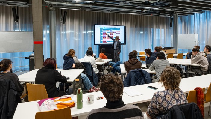 Prof. Dr. Dirk Burdinski steht an einem Board. Vor ihm sitzen die Teilnehmenden des Landesseminars.