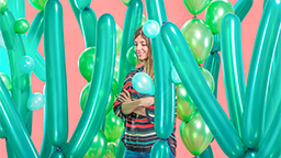 Eine Frau steht vor einem rosa Hintergrund zwischen grünen Luftballons, die wie Kakteen arrangiert sind. (Bild: Sarah Illenberger) Eine Frau steht vor einem rosa Hintergrund zwischen grünen Luftballons, die wie Kakteen arrangiert sind. (Bild: Sarah Illenberger)