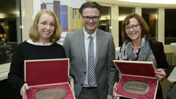 Die Absolventinnen der Forschungsstelle Medienrecht Sandra Stephan und Birgit Pieplow halten ihre Medaillen in die Kamera. (Bild: Costa Belibasakis / TH Köln)
