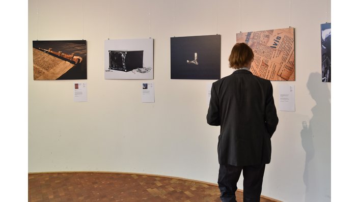 Besucher steht vor Bildern einer Ausstellung.