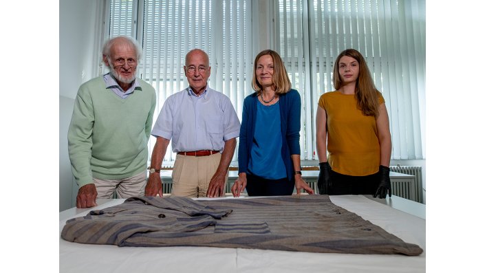 Gruppenbild, das KZ-Kleid leigt im Vordergrund