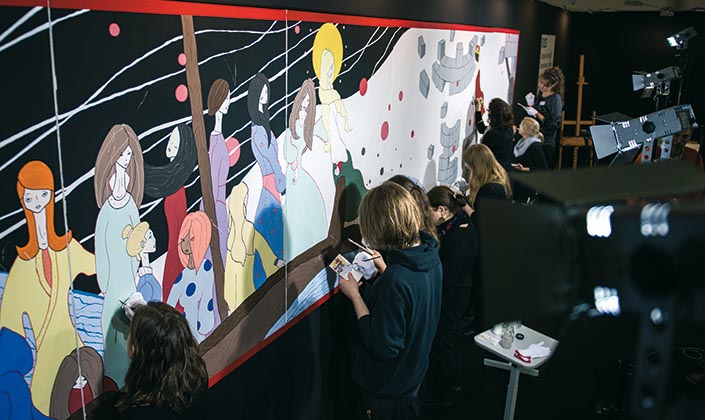 Studierende demonstrieren an einem großen Bild, wie Fehlstellen ausgebessert werden Studierende demonstrieren an einem großen Bild, wie Fehlstellen ausgebessert werden