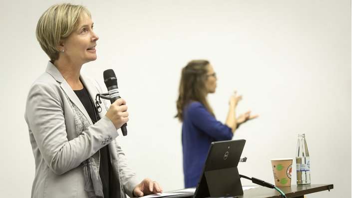 Prof. Dr. Sylvia Heuchemer, Vizepräsidentin für Lehre und Studium, steht mit einem Mikrofon in der Hand am Rednerpult