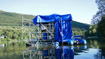 Eine schwimmende Plattform, an der ein Hochdrucksauger installiert ist, fährt kontinuierlich und weitestgehend automatisiert über einen Stausee. Dabei werden die Sedimente aufgewirbelt und zusammen mit dem Methangas aufgenommen.  (Bild: Eric Zimmermann/TH Köln)