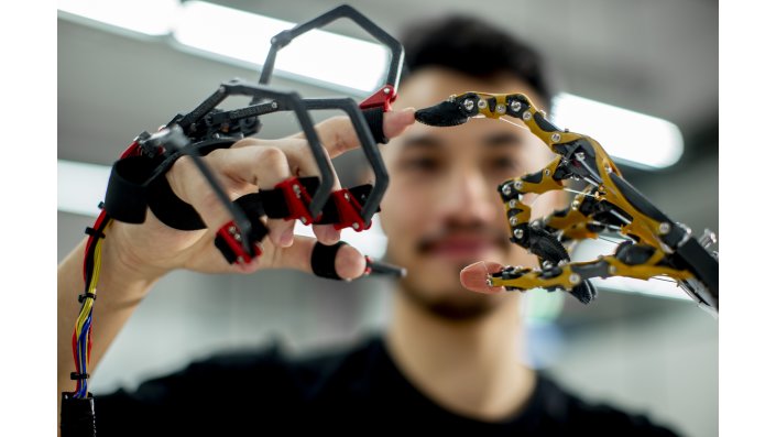 Die humanoide Hand lässt sich per Handschuh steuern, wie der Maschinenbau-Studierende Mario Mosler zeigt.