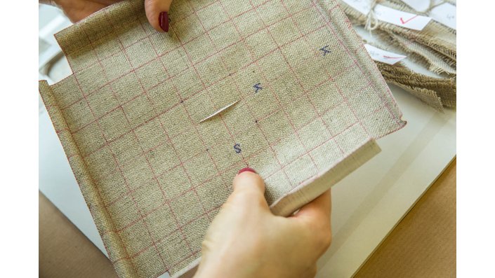 Bearbeitung einer beschädigten Leinwand: Gewichte und Nagelköpfe halten die Rissränder in der Bildebene, dann werden die Fäden verwoben und verklebt.