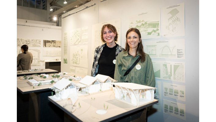 Elisa Kania und Marie Kyra Schäfer stehen hinter einem Modell. 