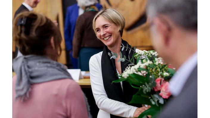 Prof. Dr. Sylvia Heuchemer wird zum Amt der Präsidentin gratulier. Sie hält einen bunten Blumenstrauß in der Hand.