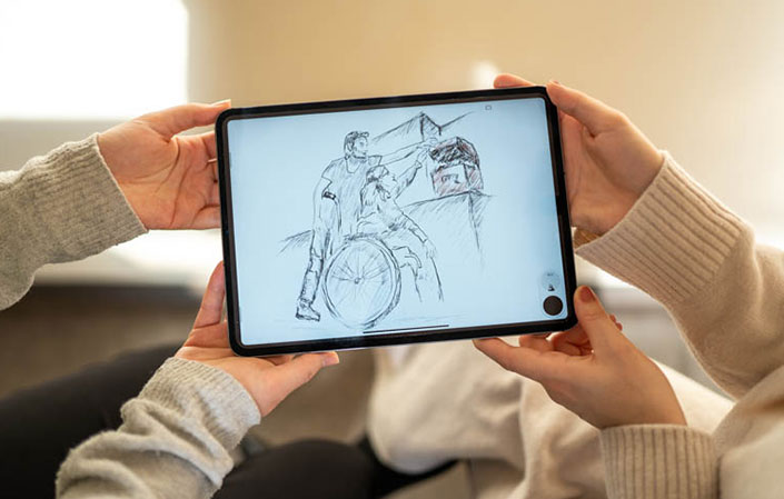Vier Hände halten ein Tablet hoch, auf dem eine Zeichnung zu sehen ist. 