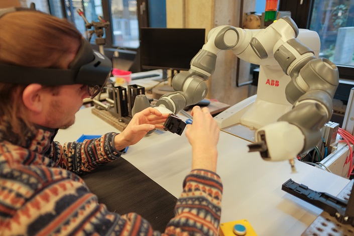 Mann, der mit Schraubenzieher an einem Roboter arbeitet Mann, der mit Schraubenzieher an einem Roboter arbeitet