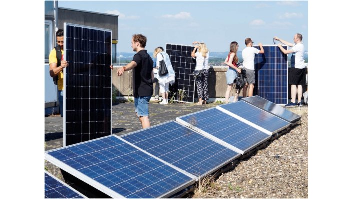 Steckersolarworkshop der TH Köln: Personen auf dem Dach der TH Köln in Deutz lernen den Einsatz von "Balkonkraftwerken"