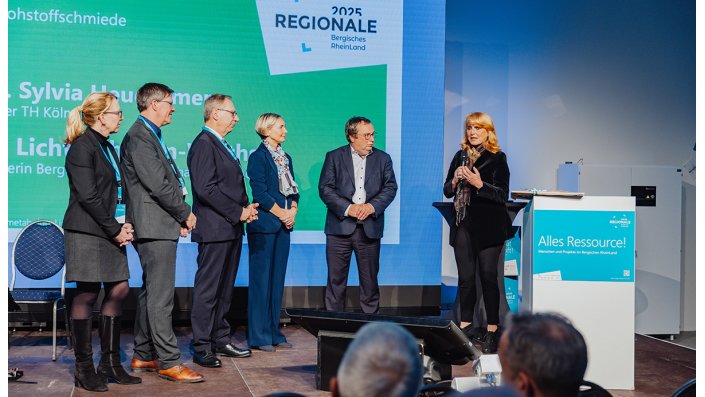 Oliver Krischer, Minister für Umwelt, Naturschutz und Verkehr des Landes Nordrhein-Westfalen (rechts im Bild), übergab den Förderbescheid für die :bergische rohstoffschmiede in Höhe von rund 12,4 Millionen Euro an Jochen Hagt, Landrat des Oberbergischen Kreises, und Prof. Dr. Sylvia Heuchemer, Präsidentin der TH Köln.
