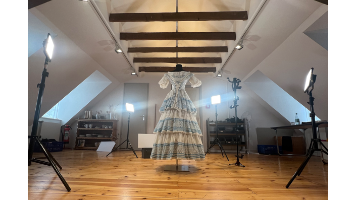 Ein historisches Kleidungsstück wird beleuchtet und abfotografiert.