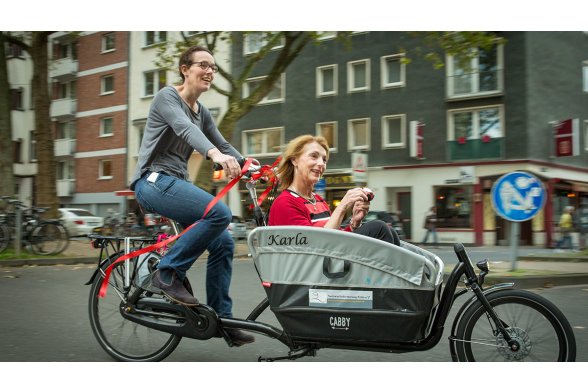 Melanie Werner, wissenschaftliche Mitarbeiterin an der TH Köln, und Prof. Dr. Karla Misek-Schneider bei der Probefahrt mit dem Lastenfahrrad 