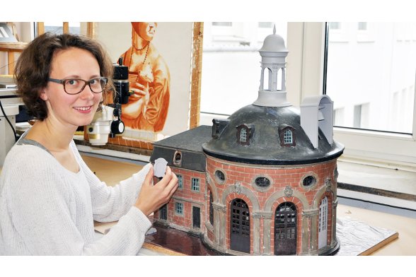 Sonja Fröhlich bringt die im 3D-Drucker entstandenen Nachbildungen an