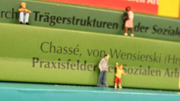 Kleine Miniaturfiguren klettern auf Büchern herum (Bild: Melanie Werner) Kleine Miniaturfiguren klettern auf Büchern herum (Bild: Melanie Werner)