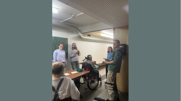 Mehrere Personen stehen auf einer Kegelbahn und lächeln.