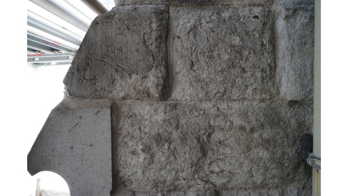 Eine Außenwandfläche aus Drachenfels Trachyt Bausteinen, deren Oberflächen stark zurückgewittert sind.