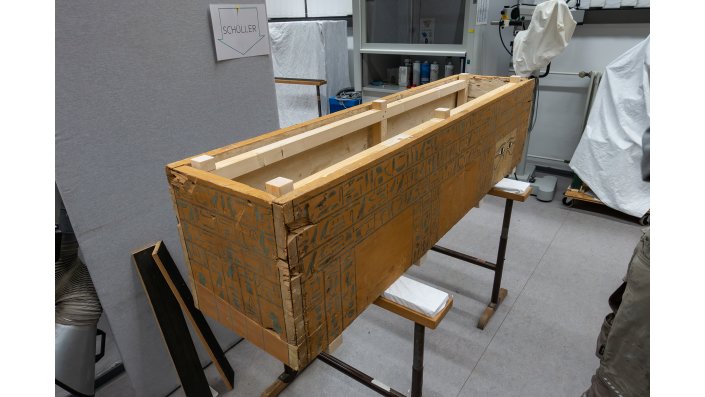 An das vorhandene Behelfsgestell im Inneren des bodenlosen Sarges wurden weitere Bauteile angesetzt, die in der Ausstellungssituation den Sargdeckel tragen.