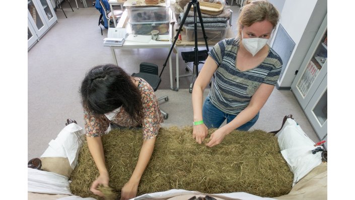 Maria Miltschitzky und Carla Grewer verzupfen das Füllmaterial, damit sich aus dem portiionsweise eingebrachten Material eine Einheit bildet. Würde der Lasierstich das Material nicht festhalten, dann sollte es sich als Matte abheben lassen können.