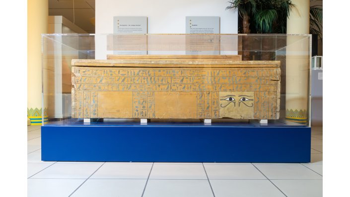 Der Sarg der Sat Sobek auf seinem neuen Spezialsockel im Gustav-Lübcke-Museum. Der Plexiglassturz und der Blendsockel berühren das schwingungsreduzierende Innenleben der Spezialkonstruktion nicht.