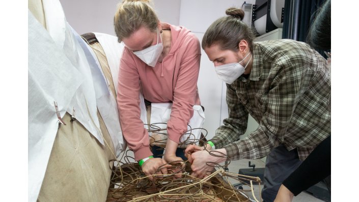 Das Bild zeigt deutlich, wie schwierig dieser Arbeitsschritt ist. Carla Grewer und Dominic Huber "kämpfen" mit der Schnürung und den Federn.