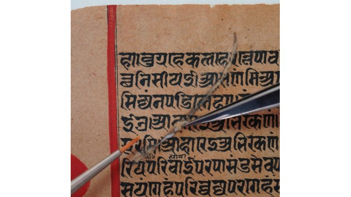 Folio 68189 Verso. Mechanische Stabilisierung und Sicherung des durch Kupferfraß entstandenen Risses mit Materialverlust durch Einsetzen von Japanpapier-Intarsien.