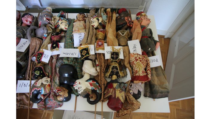 Mehrere Puppenspielfiguren liegen auf einem Tisch.