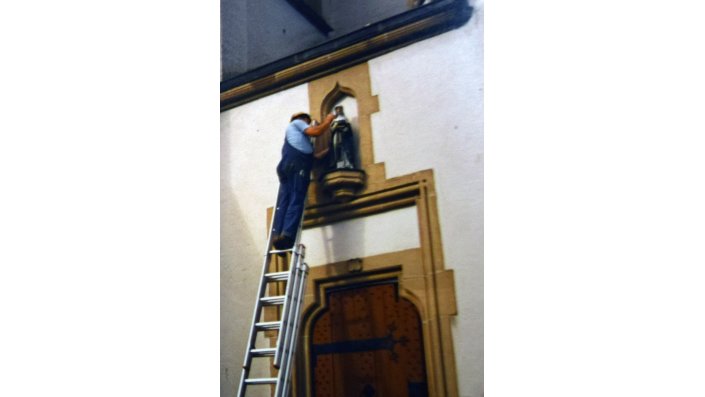 29. Juli 1987: Nach der Restaurierung wird die Plastik mit ihrer damaligen Fassung wieder an der Kirchenfassade versetzt.