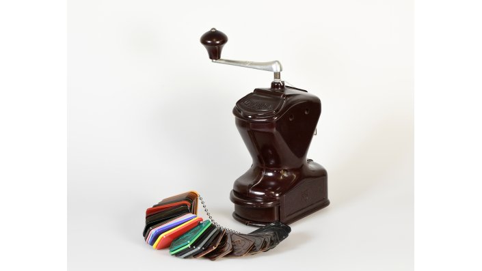 Kaffeemühle aus den 1920er Jahren, abgebildet mit einer Farbmusterkette, beides aus Phenoplast.