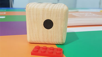 Bild von einem Holzklotz und einem Legostein auf einem Tisch (Bild: privat)