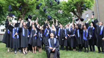 Ein Gruppenfoto der Bachelorabsolventen des Wintersemesters 2014/2015 beim Hochwerfen der Hüte (Bild: Stefanie M. Halwas / FH Köln)