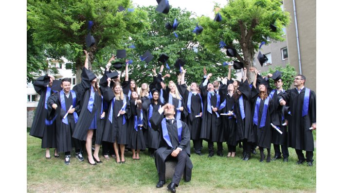 Ein Gruppenfoto der Bachelorabsolventen des Wintersemesters 2014/2015 beim Hochwerfen der Hüte