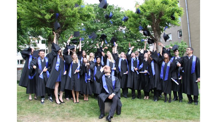 Ein Gruppenfoto der Bachelorabsolventen des Wintersemesters 2014/2015 beim Hochwerfen der Hüte