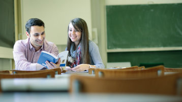 Studenten im Gespräch im Vorlesugnsraum, Tafel groß im Hintergrund (Bild: Thilo Schülgen / FH Köln)