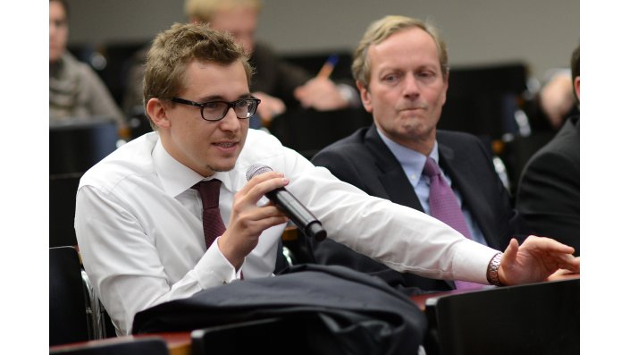 Ein Teilnehmer aus dem Auditorium stellt eine Frage an das Podium