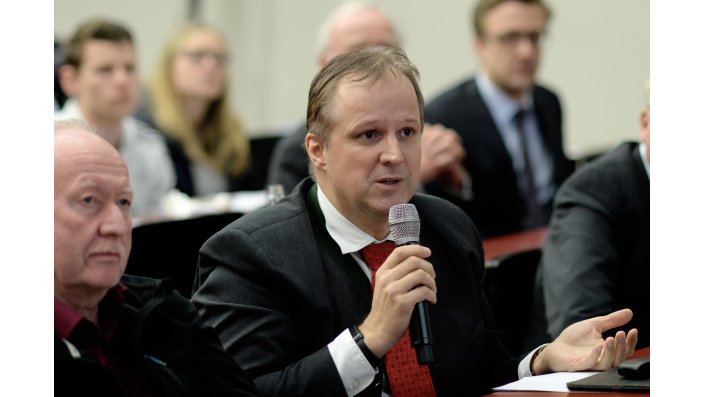 Ein Teilnehmer des Symposiums stellt eine Frage an das Podium