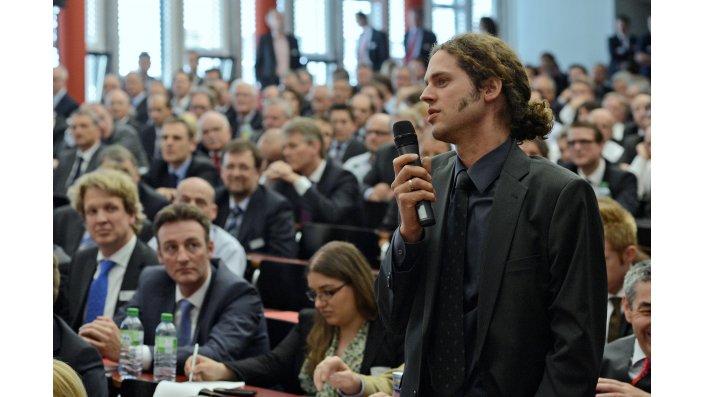 Ein Teilnehmer aus dem Auditorium diskutiert mit dem Panel