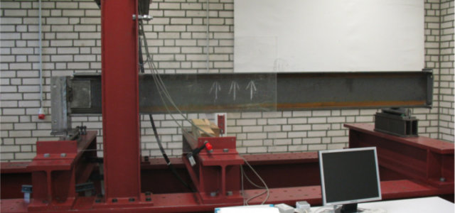 Ein Stahlträger wird in einem Prüfrahmen belastet (Bild:Damm / TH Köln)