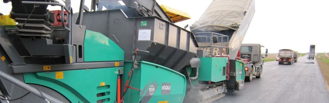 Ein Asphaltfertiger wird während des Asphaltierens mit Mischgut befüllt (Bild: Bernd Heinen / TH Köln)